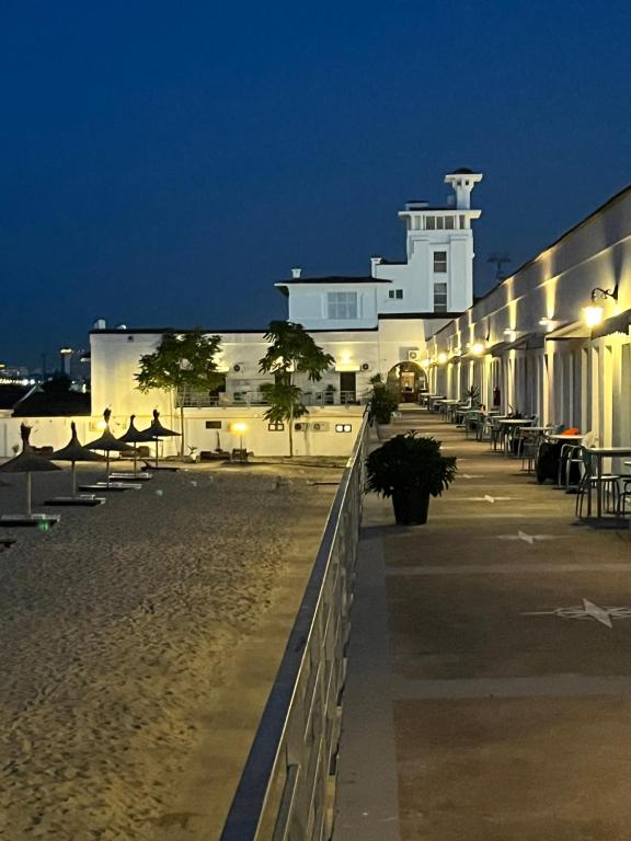a building on the beach at night at Hostel Cazino Nord Rooms in Mamaia