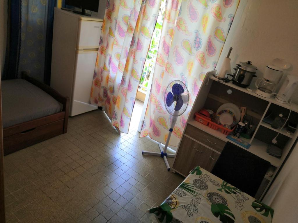 a room with a table and a window with curtains at LocaTriolet in Saint-Denis