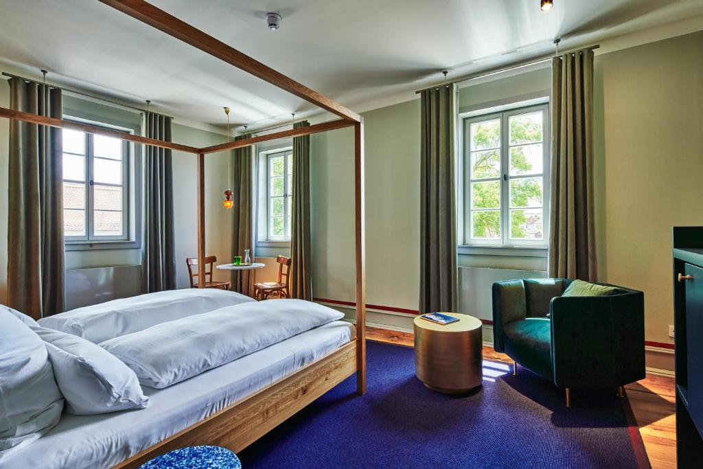um quarto com uma cama de dossel e uma cadeira em Pension Alter Bischofshof em Naumburg