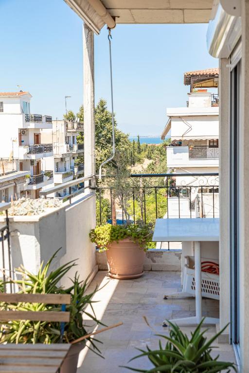 a balcony with a table and a view of the ocean at Houseloft Kalamaria Highview in Thessaloniki