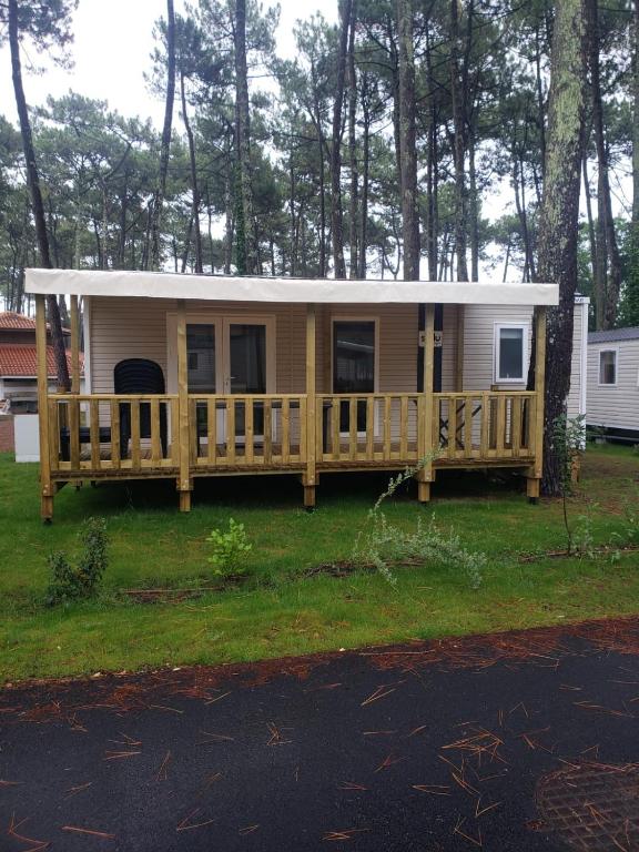 a tiny house with a porch and a deck at Mobil home 4&#47;6 personnes in Seignosse