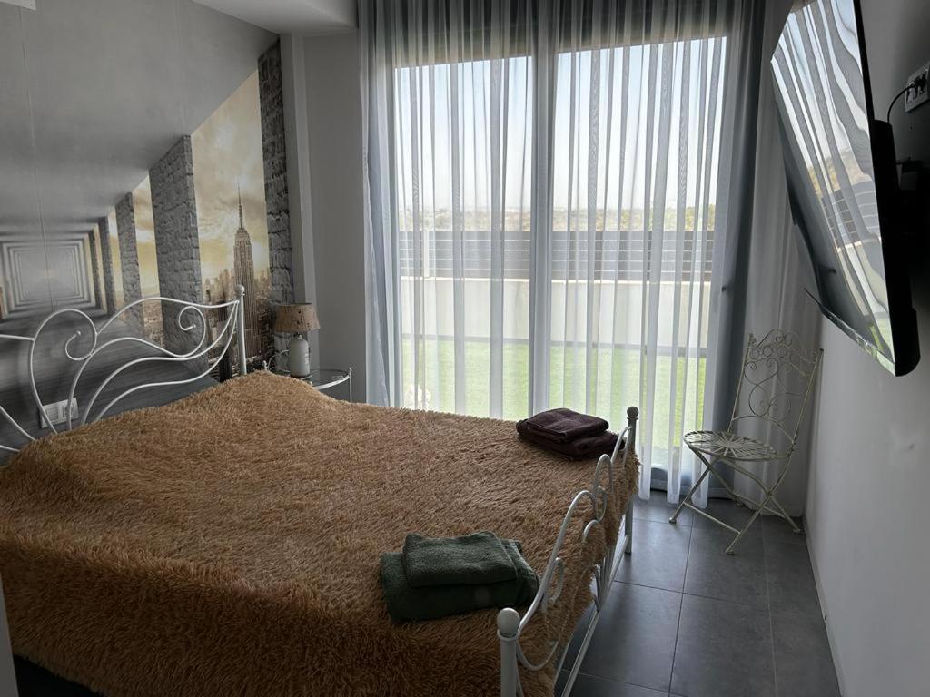 um quarto com uma cama grande e uma janela grande em Brilliant Villa em Gran Alacant