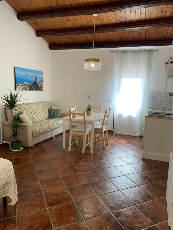 sala de estar con mesa y sofá en La mansarda di nonno Calogero, en Montelepre