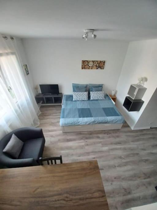 une chambre avec un lit, une chaise et une table dans l'établissement L'Escale, À proximité immédiate de la gare, à Dijon