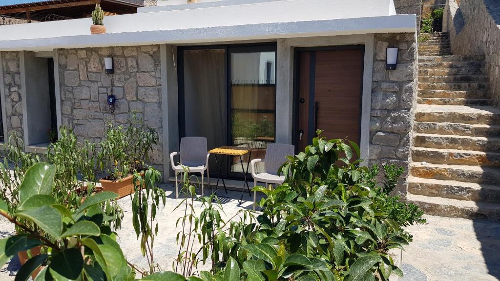 a house with a patio with chairs and plants at Bodrum Turgutreis Apart in Karabağ