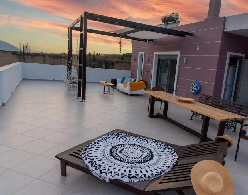 a rooftop patio with a table and chairs and a sunset at Psm Luxury Living in Kánithos