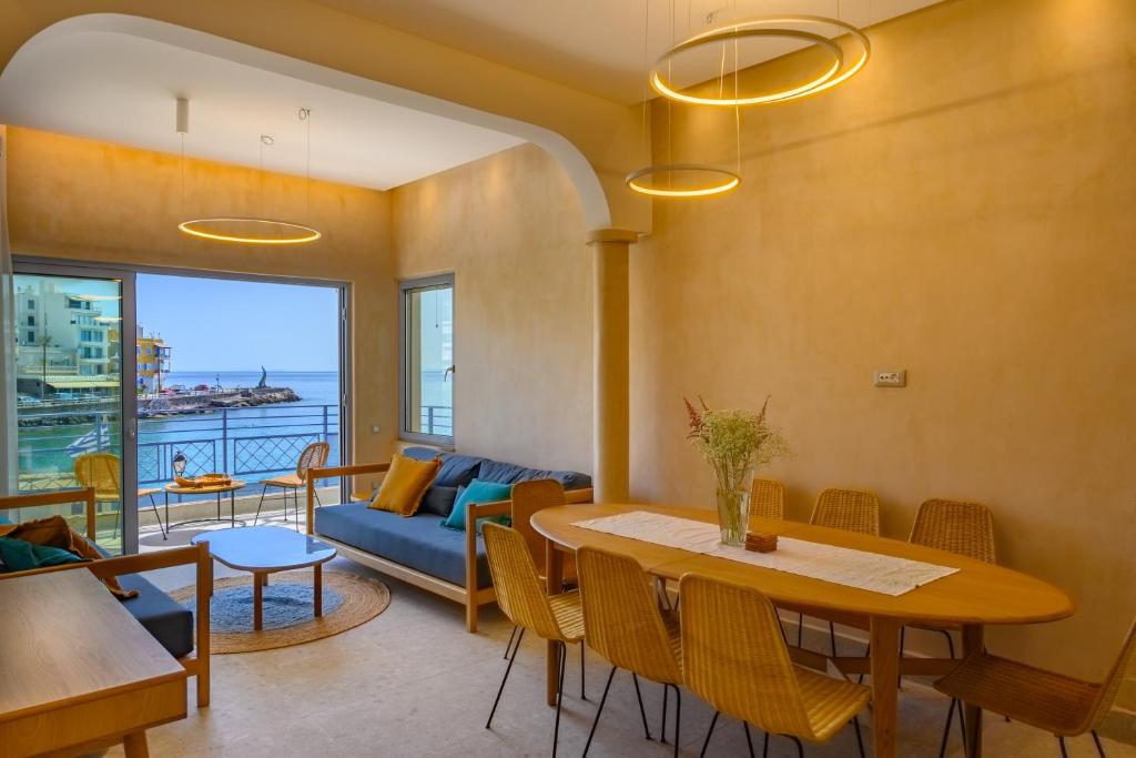 a living room with a table and a couch at Asteria Seafront Luxury Apartment in Agios Nikolaos