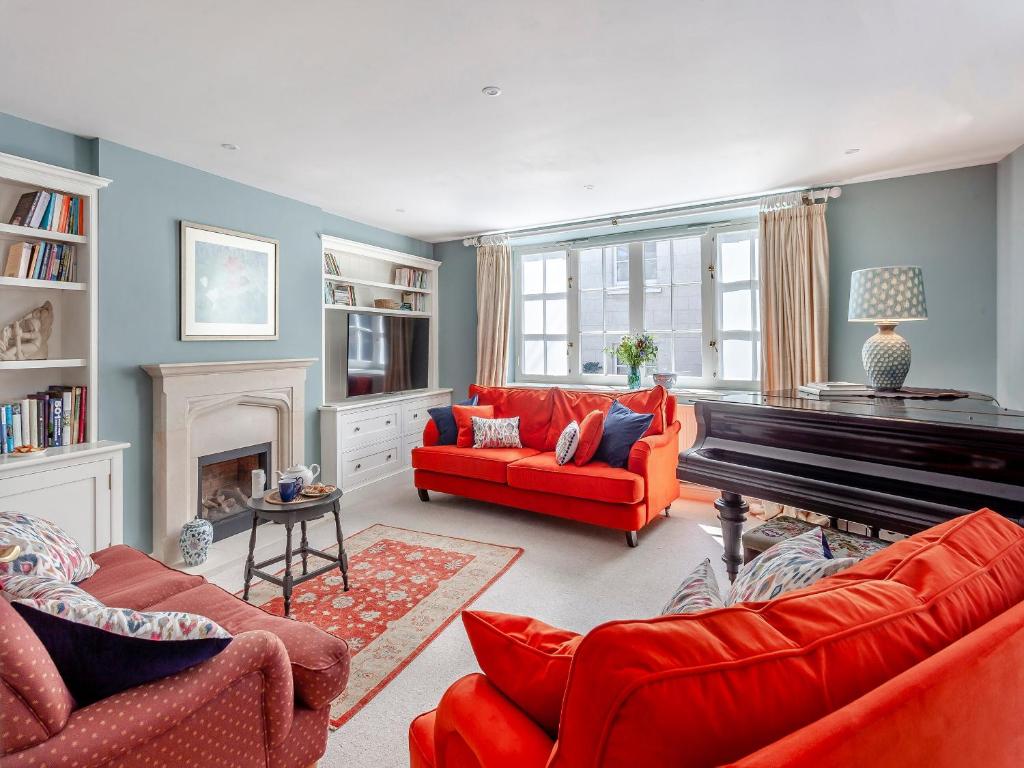 sala de estar con muebles de color rojo y piano en Beautiful Cottage In Shaftesbury With 3 Bedrooms And Wifi, en Shaftesbury