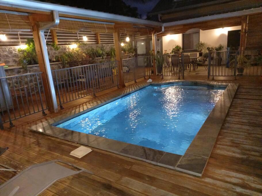 une grande piscine avec une terrasse en bois dans l'établissement Haut de villa avec piscine, à Saint-Joseph