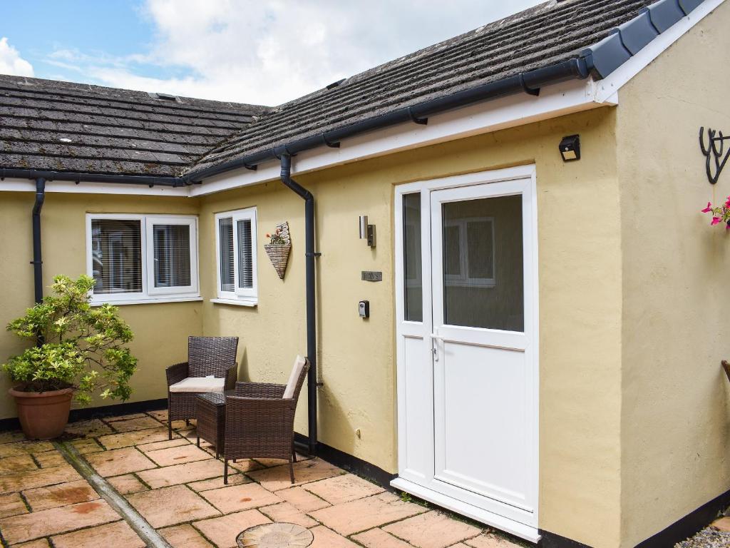 a house with a white door and a patio at Roxys Cottage - Uk44687 in Burnopfield