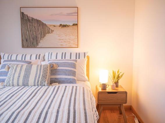 1 dormitorio con 1 cama con rayas azules y blancas en Keilor airport stay en Albion