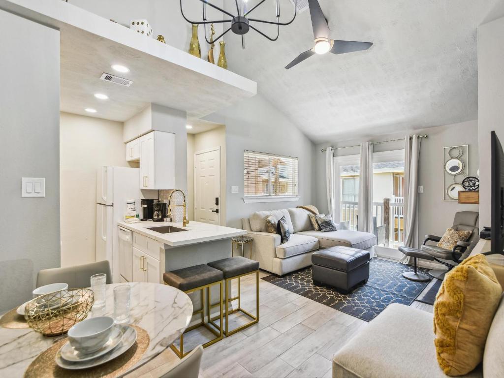 Una cocina y una sala de estar con un sofá y una mesa. en Palms At Cove View 806 - Bougie Beach Bungalow, en Galveston