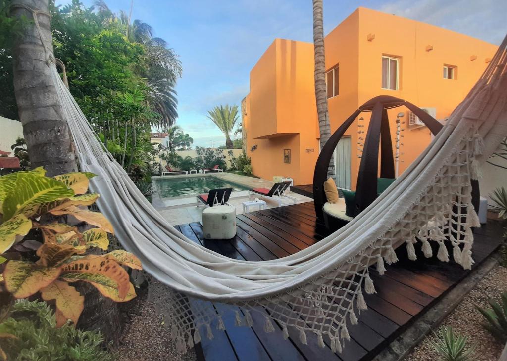 a hammock on a deck next to a house at Libert Hotel in Porlamar