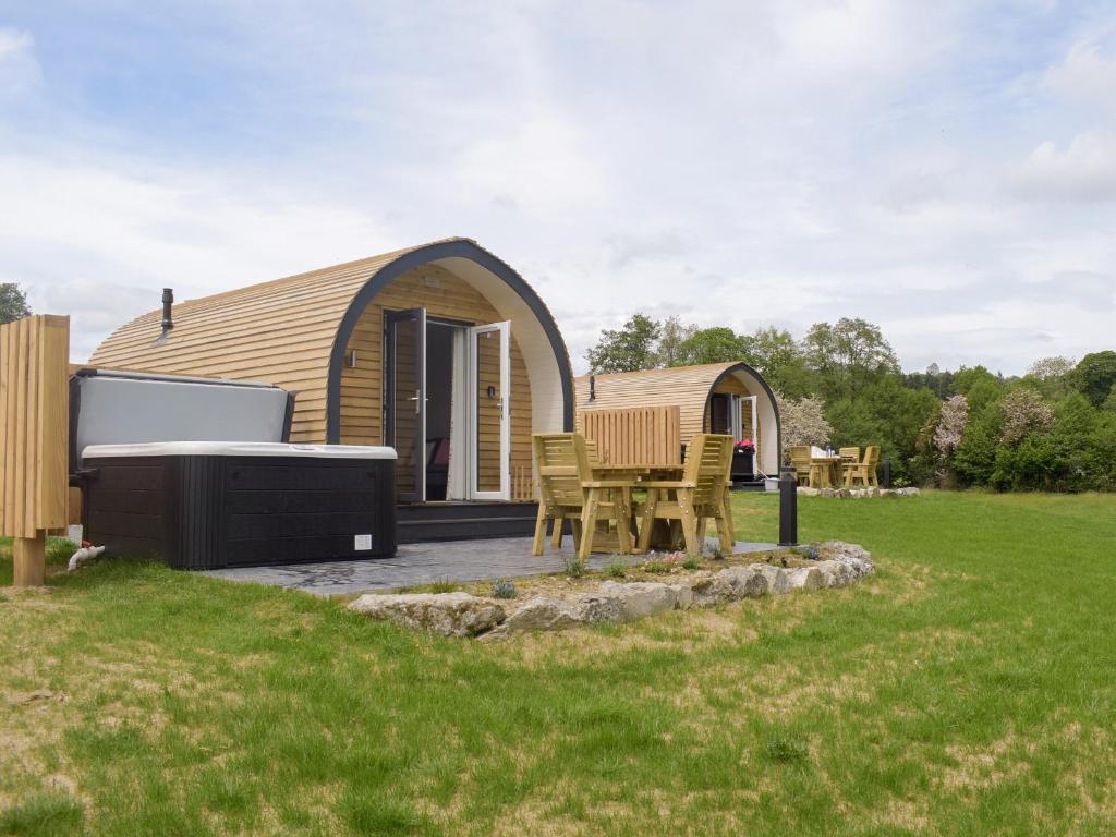 a small tent with a table and chairs in a yard at Cain Pod Vip in Llanfyllin