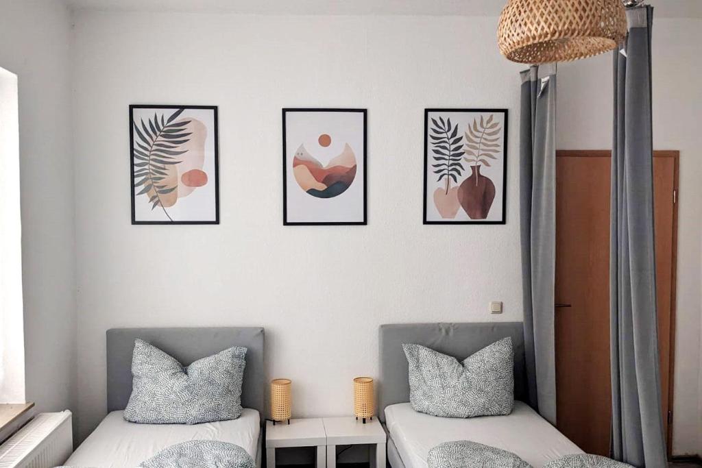 una camera con due letti e quattro immagini sul muro di Nice Apartment with Balcony a Apolda