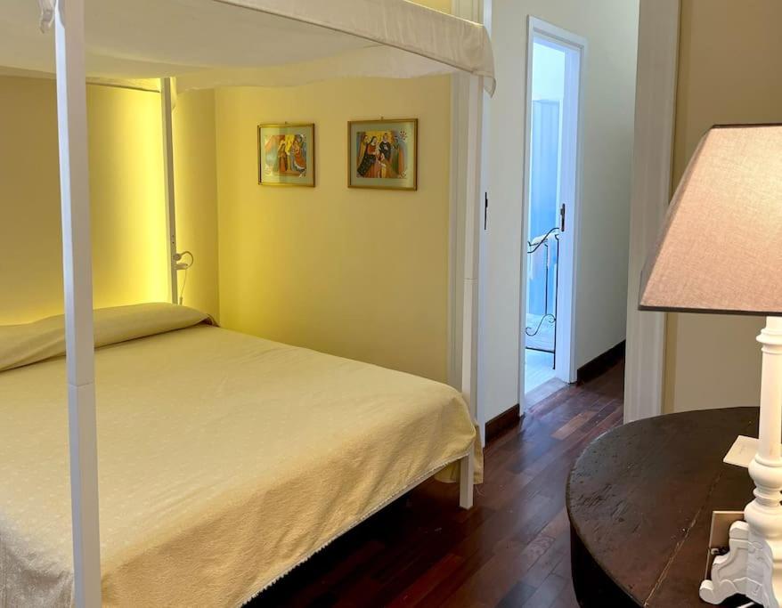 um quarto com uma cama e uma mesa com um candeeiro em La casa del Maestro em Palermo