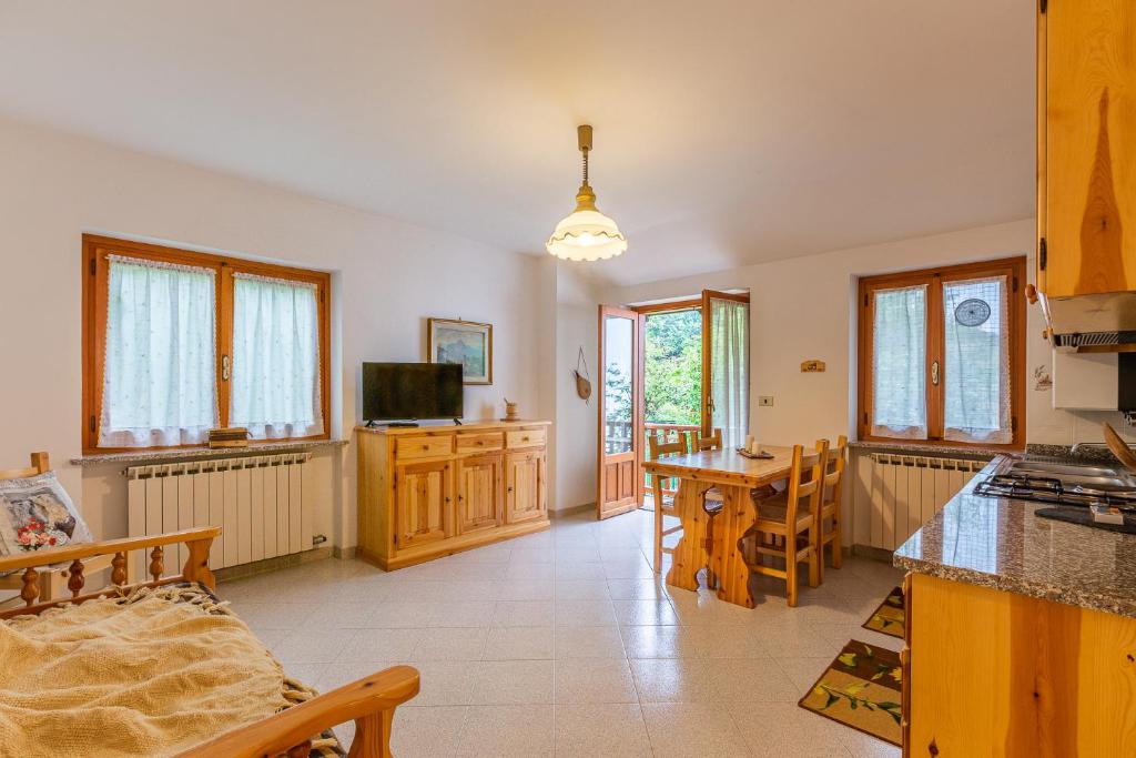 a kitchen and living room with a table and chairs at Maison Bertines II in Casteldelfino