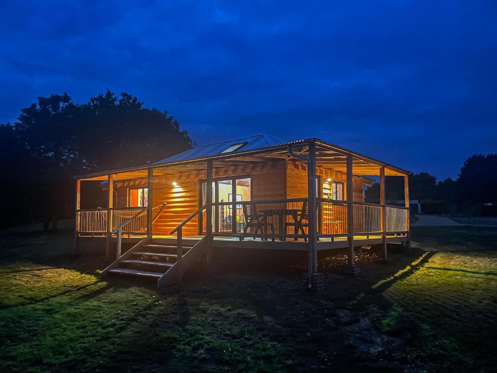 a large wooden house with a lit up facade at night at Okovango - Uk44824 in Holton