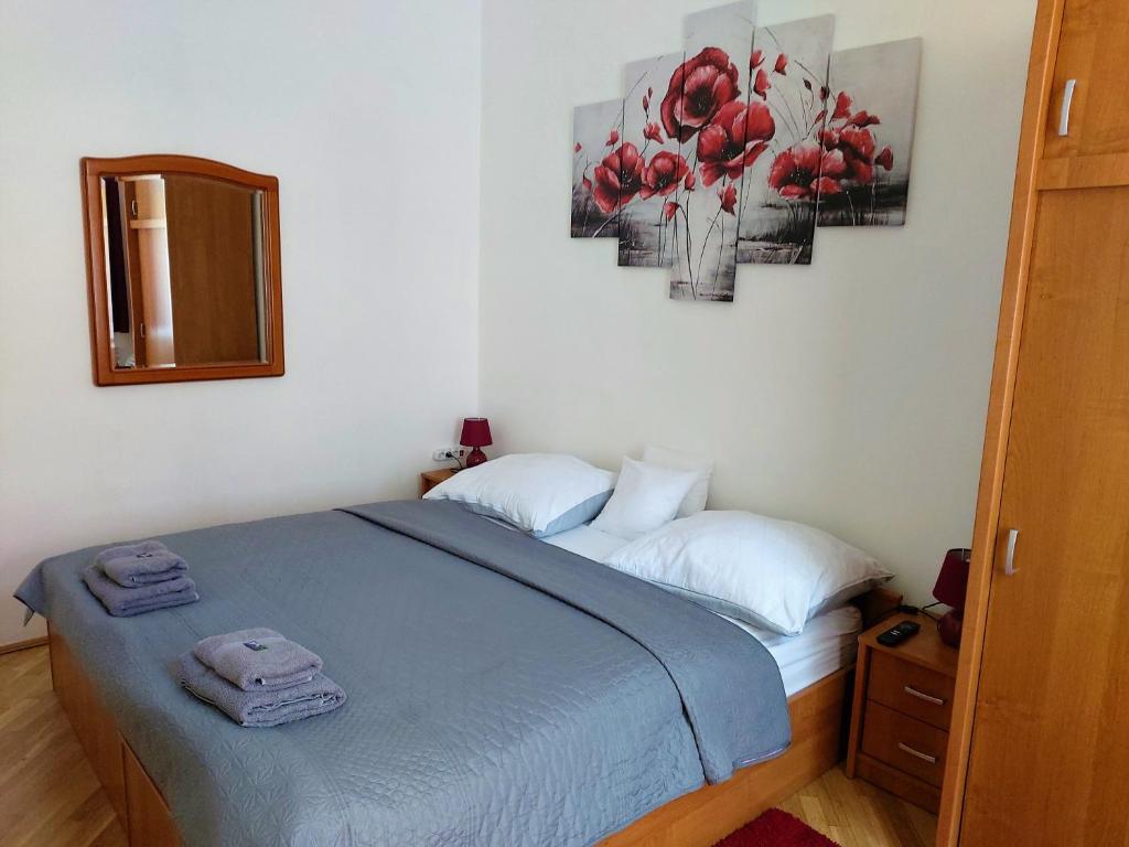 a bedroom with a bed with two towels on it at Little Hungary Apartment in Budapest