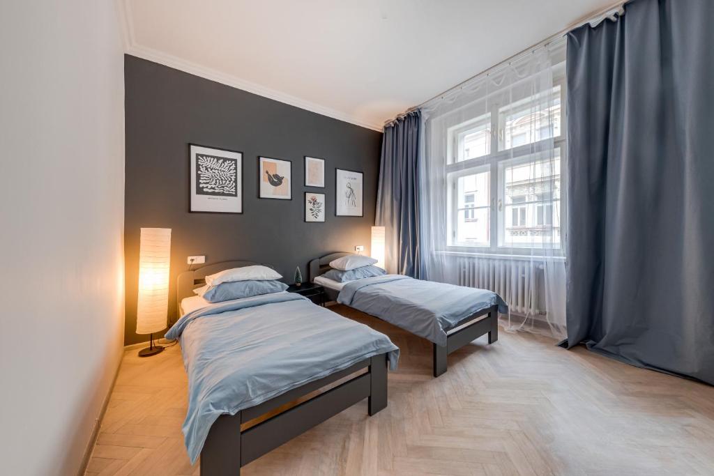 プラハにあるVita Nejedleho apartmentsのベッドルーム1室(ベッド2台、窓付)