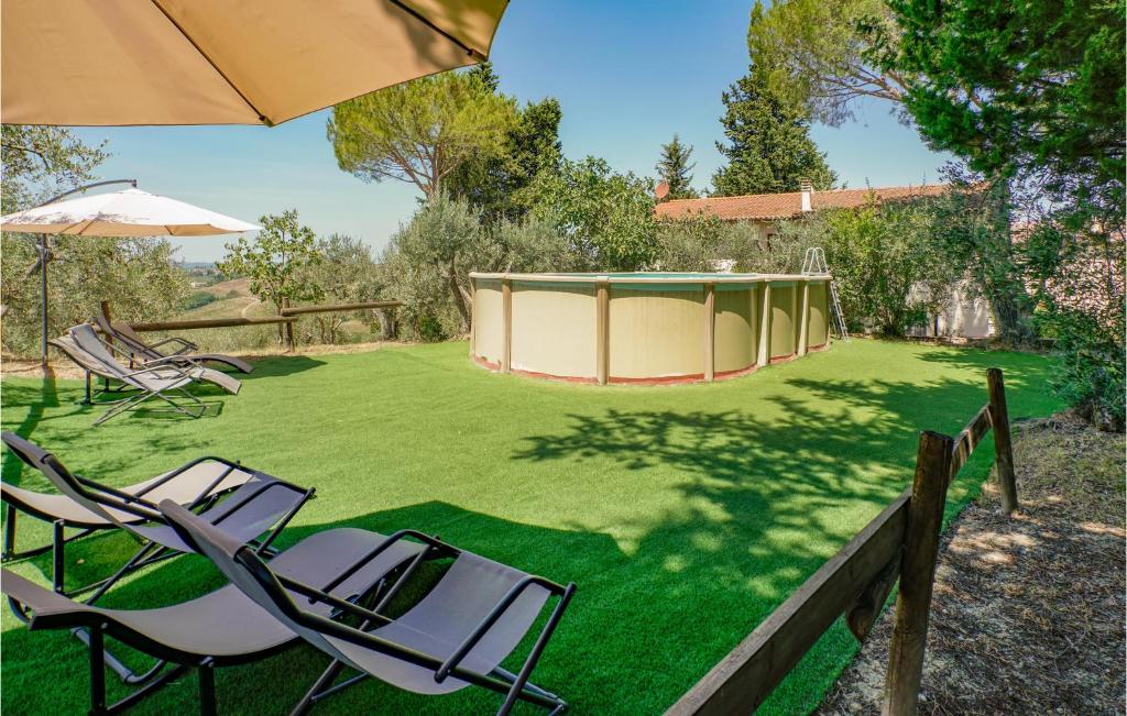 een paar stoelen en een paraplu in een tuin bij Cozy Home In Montespertoli With Outdoor Swimming Pool in Montespertoli