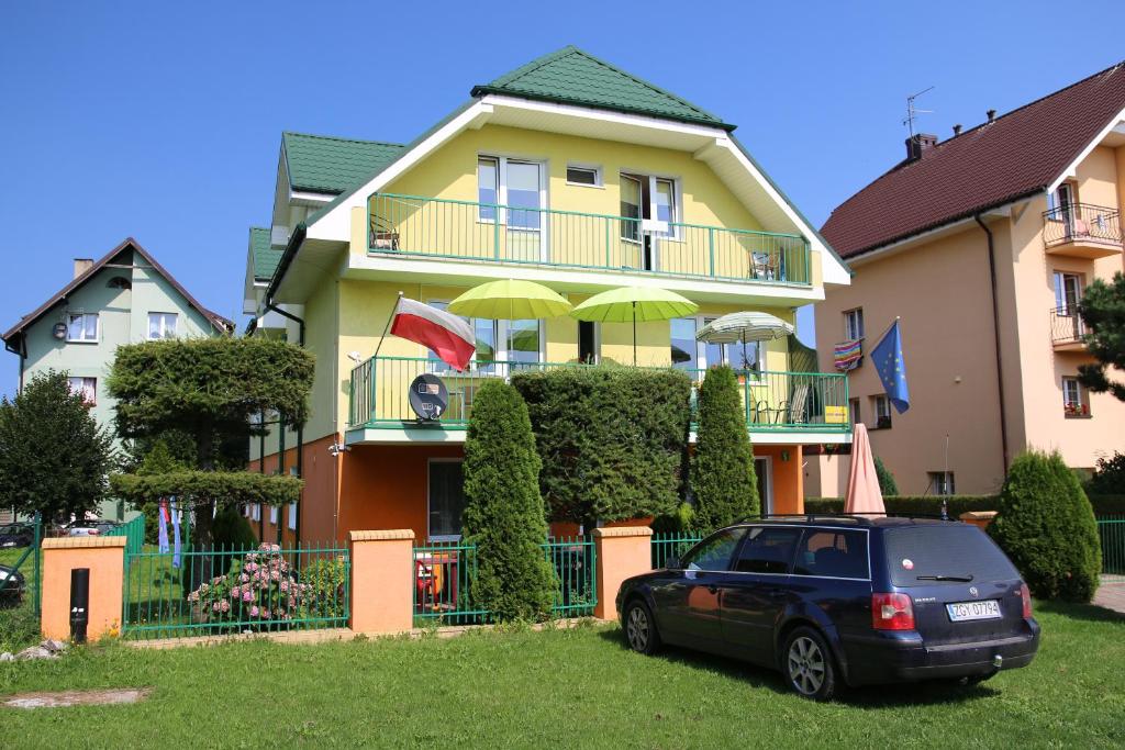 a house with a car parked in front of it at Willa Elżbieta in Rewal