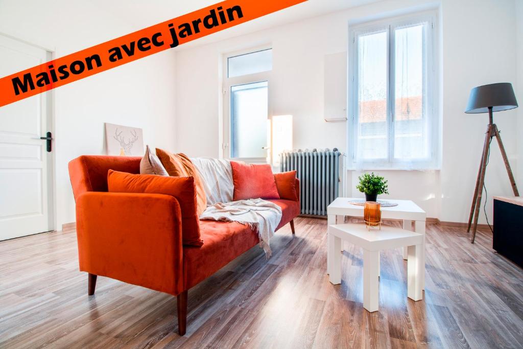 a living room with an orange couch and a table at ✦ Maison avec jardin - Plaza Verde✦ in Commentry