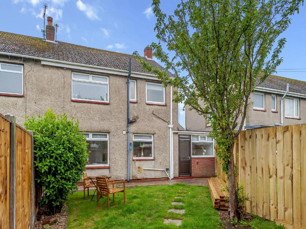 a house with a wooden fence and a yard at Castle View House in Amble