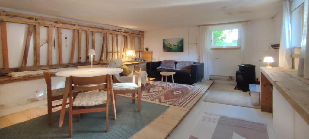 a living room with a table and a couch at Studio to rent in Walterswil