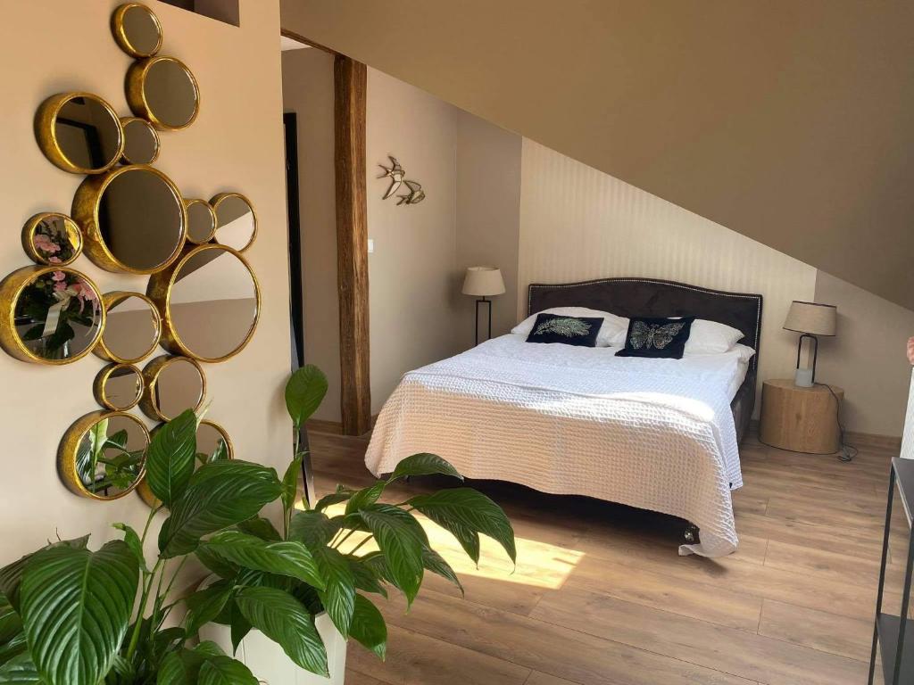 a bedroom with a bed and mirrors on the wall at Apartament Młyńska in Augustów