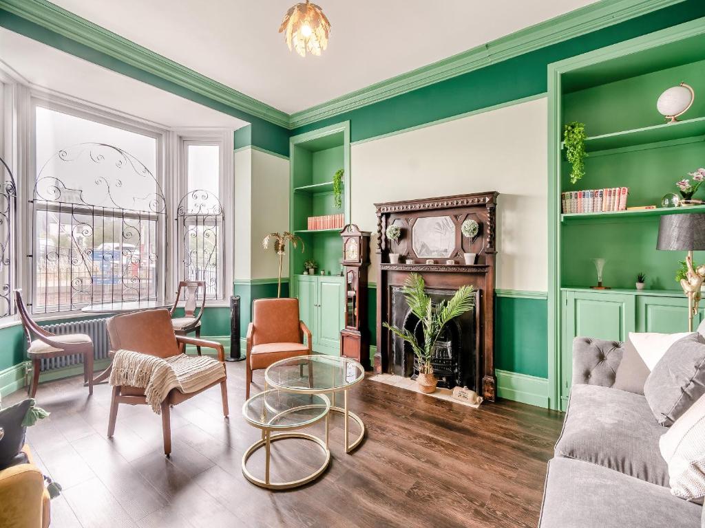 een woonkamer met groene muren en een bank en stoelen bij Temperance House in Selby