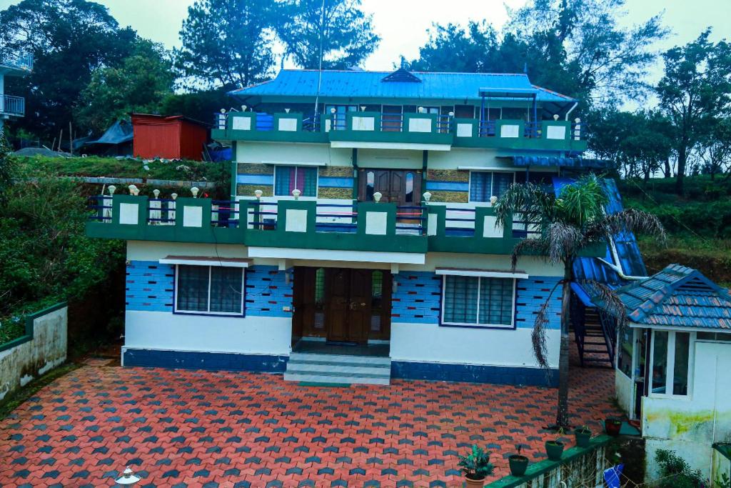 a house with a blue roof and a red tile floor at Mount view Holidays in Vagamon