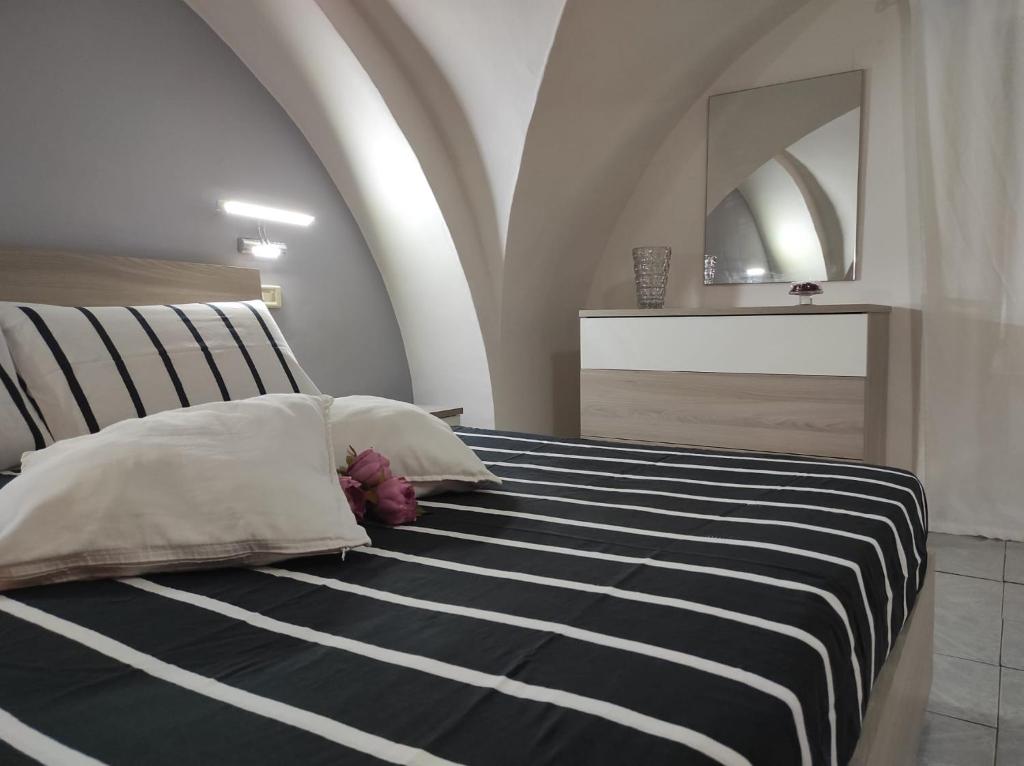 sypialnia z łóżkiem z czarno-białym kocem o paskach w obiekcie Maya's house w Katanii