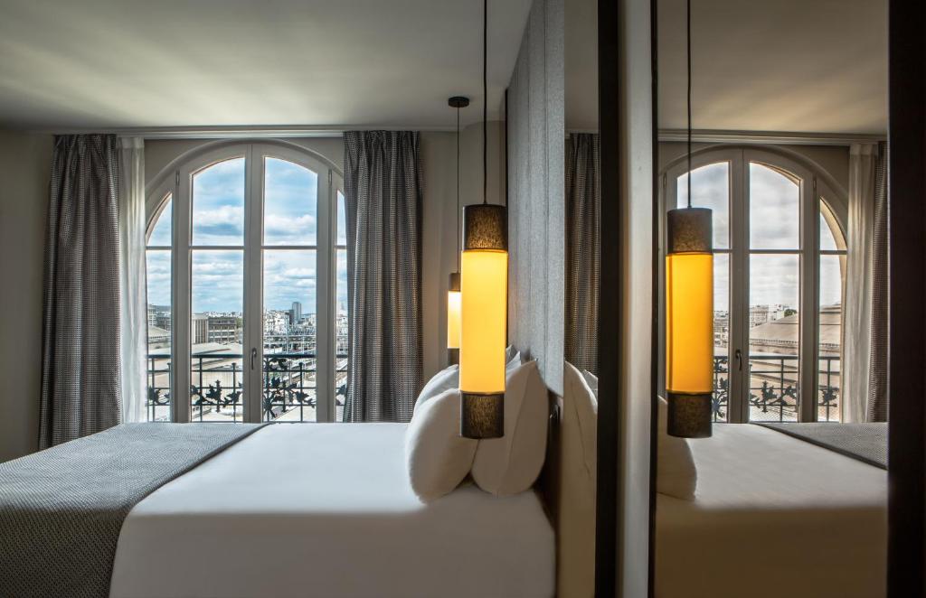 a bedroom with a bed and a window with a view at Hotel Flanelles Paris in Paris