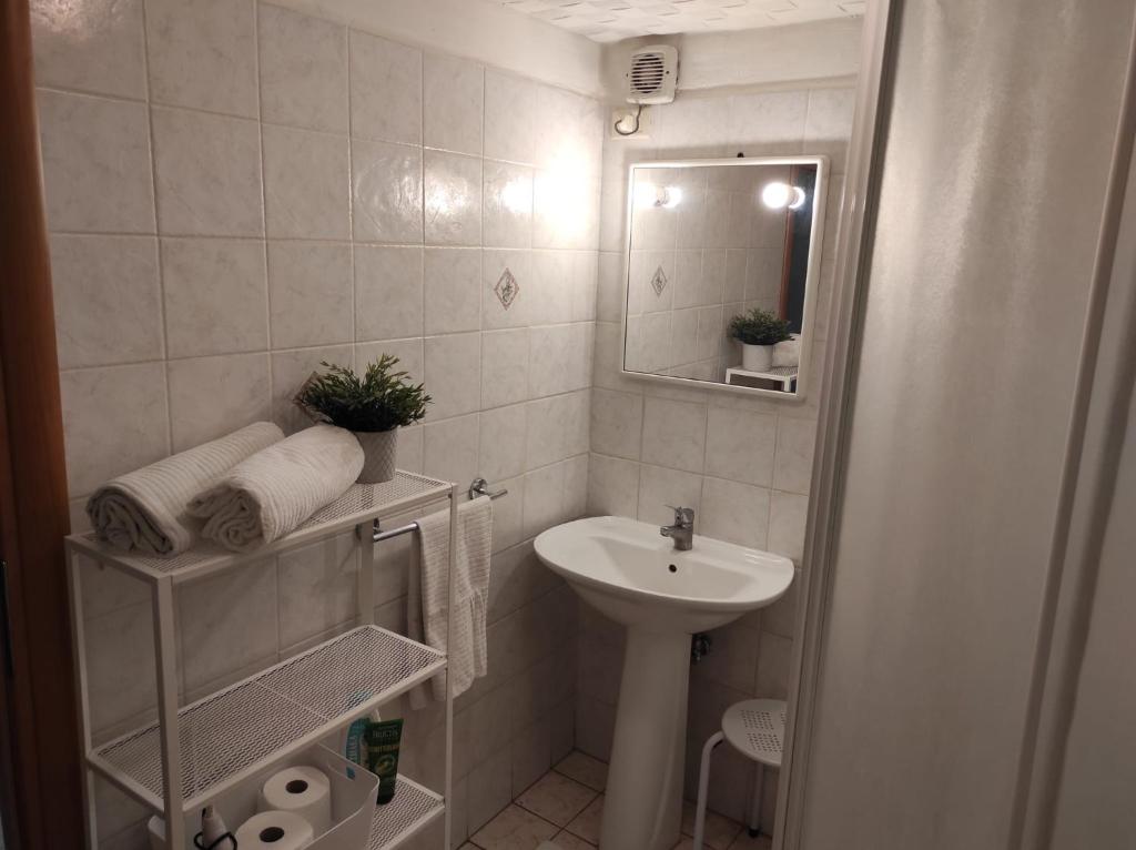biała łazienka z umywalką i lustrem w obiekcie Maya's house w Katanii