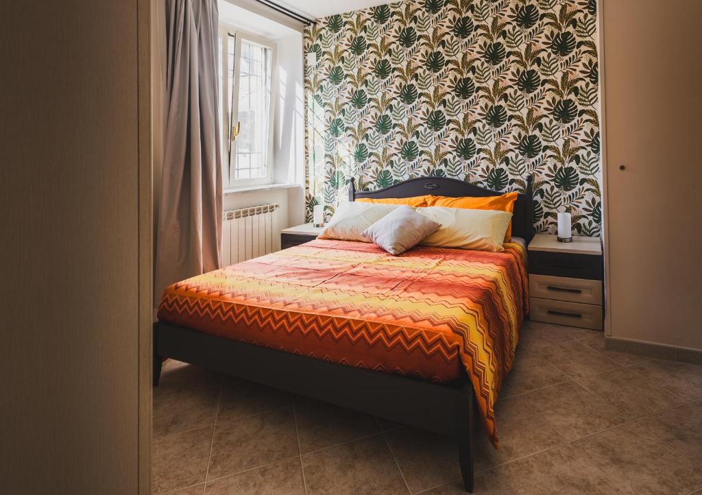 a bedroom with a bed with a patterned wall at Casa Dolce Casa in Orvieto