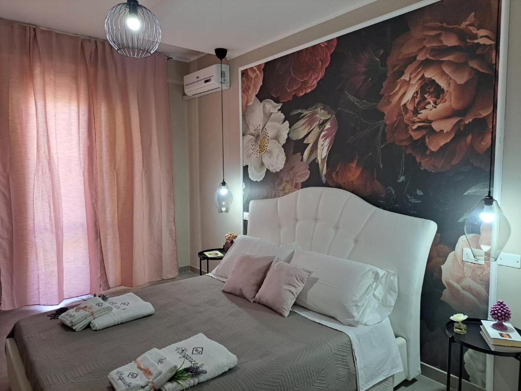 ein Schlafzimmer mit einem Blumenbild an der Wand in der Unterkunft elegance b&b in Cariati