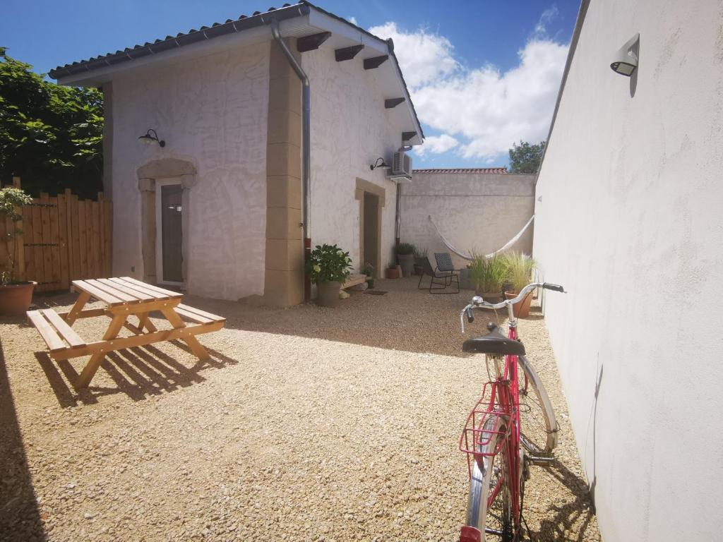 een fiets geparkeerd naast een gebouw met een picknicktafel bij Le Petit Saugnieu in Colombier-Saugnieu