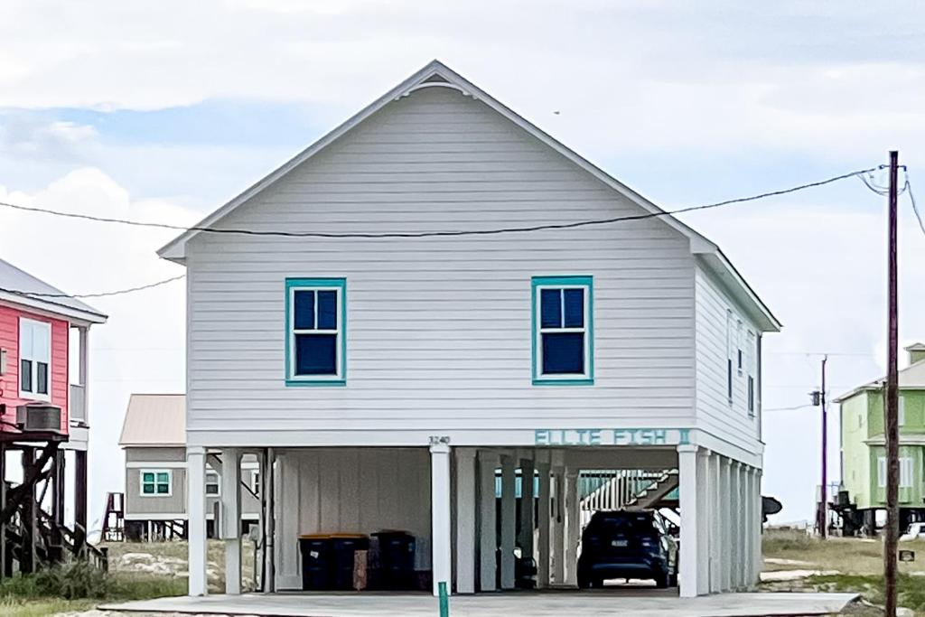 uma casa branca com janelas azuis em cima em Ellie Fish em Gulf Shores