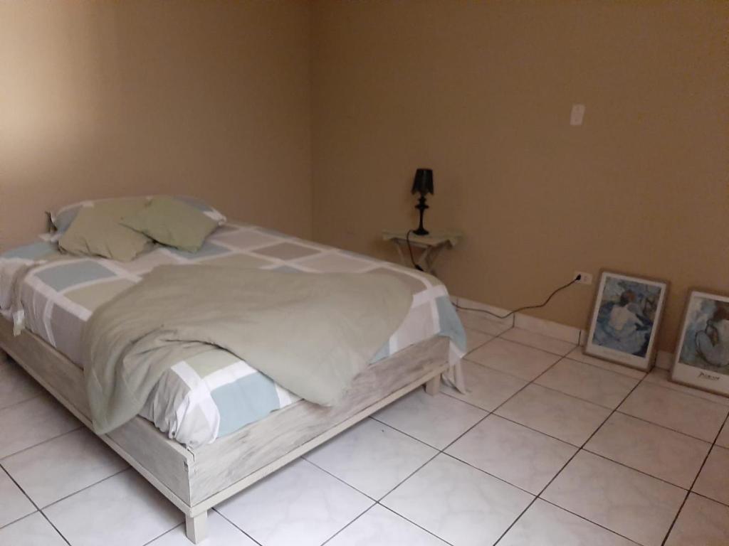 a bedroom with a large bed and a tiled floor at ArenaNorte in Pimentel