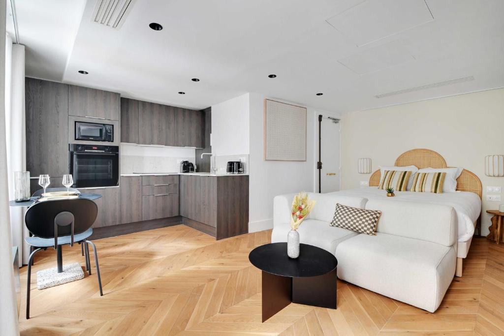 een woonkamer met een witte bank en een tafel bij Brand New Modern Studio in Central Paris - 2P - B1 in Parijs