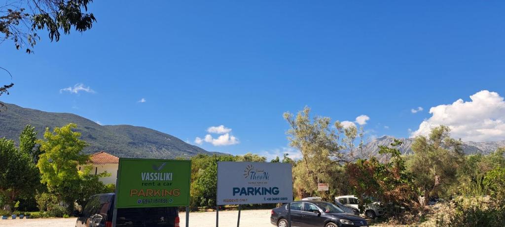 two signs in front of a parking lot with a car at Grand TheoNi Boutique Hotel & Spa in Vasiliki