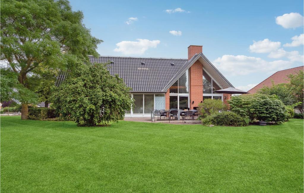 dom z zielonym trawnikiem przed nim w obiekcie Lovely Home In Nyborg With Swimming Pool w mieście Nordenhuse
