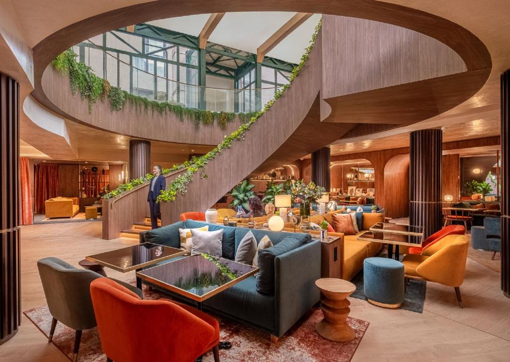 a lobby of a hotel with a spiral staircase at Hôtel Burdigala by Inwood Hotels in Bordeaux