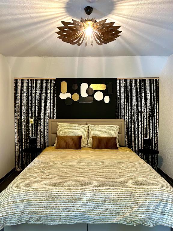 Un dormitorio con una cama grande y una lámpara de araña. en Les Chambres T4, en Huy