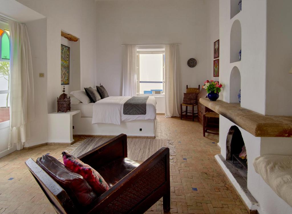 un soggiorno con letto e camino di Villa Maroc Essaouira a Essaouira