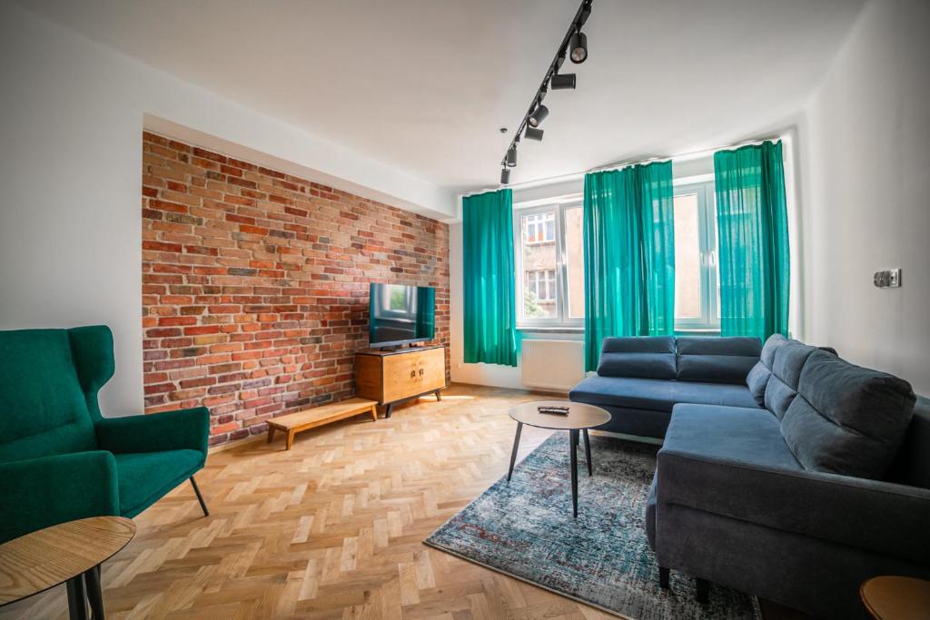 a living room with a couch and a brick wall at Vistula River Modern Apartment in Krakow