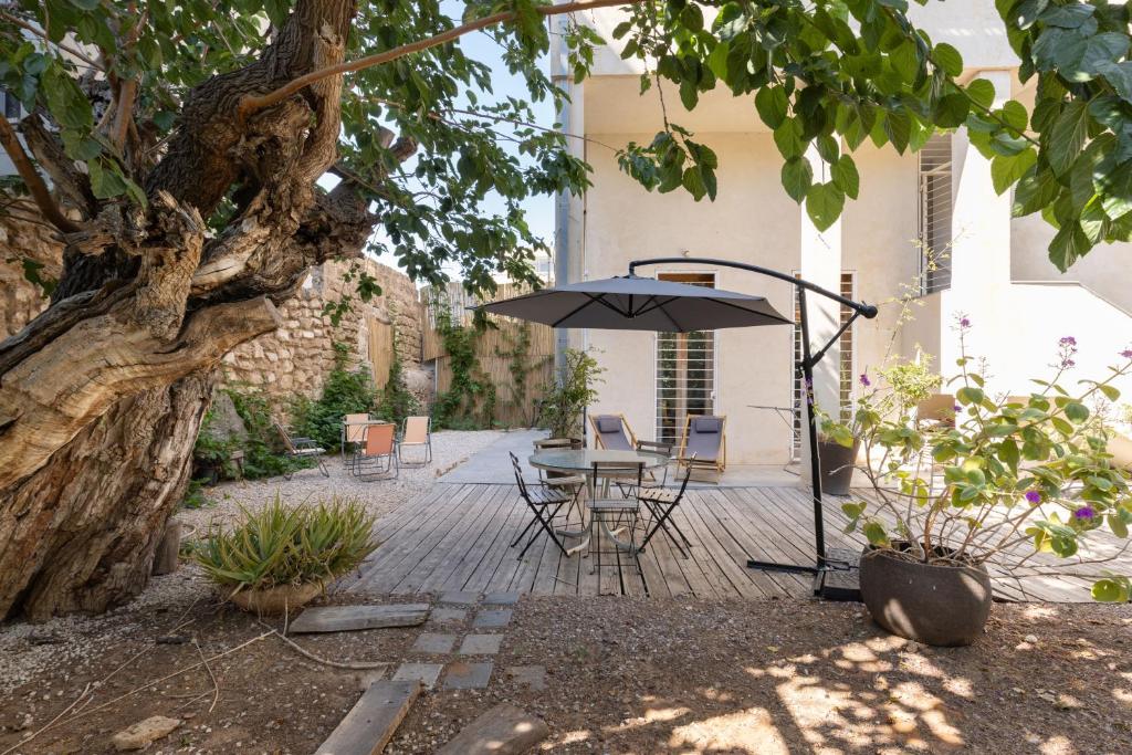 un patio con sombrilla, mesa y sillas en Secret Garden in Jaffa + Free Parking, en Tel Aviv