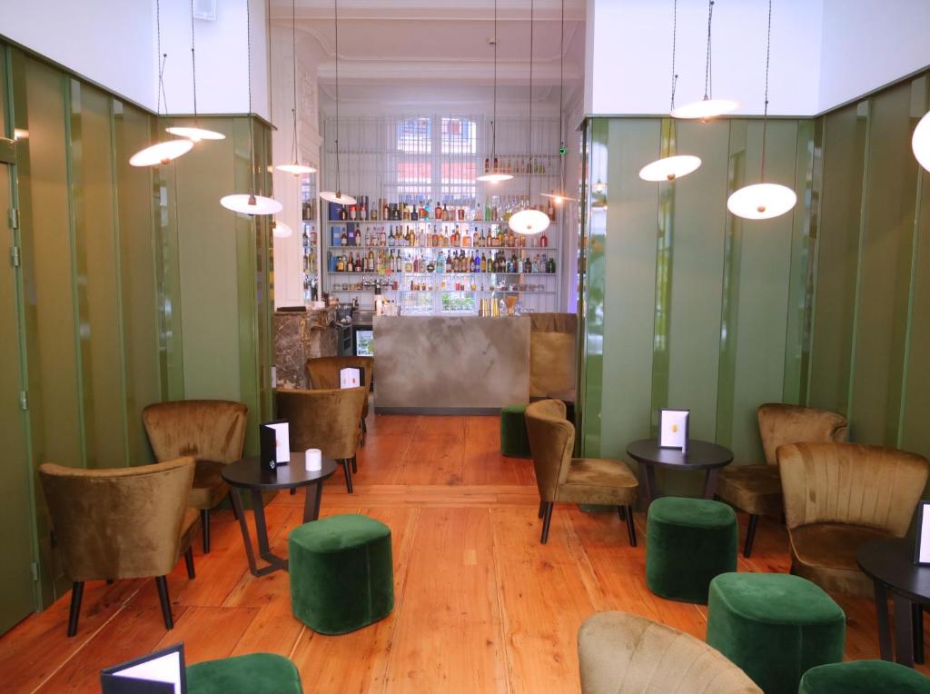 a restaurant with green walls and tables and chairs at Clarance Hotel Lille in Lille