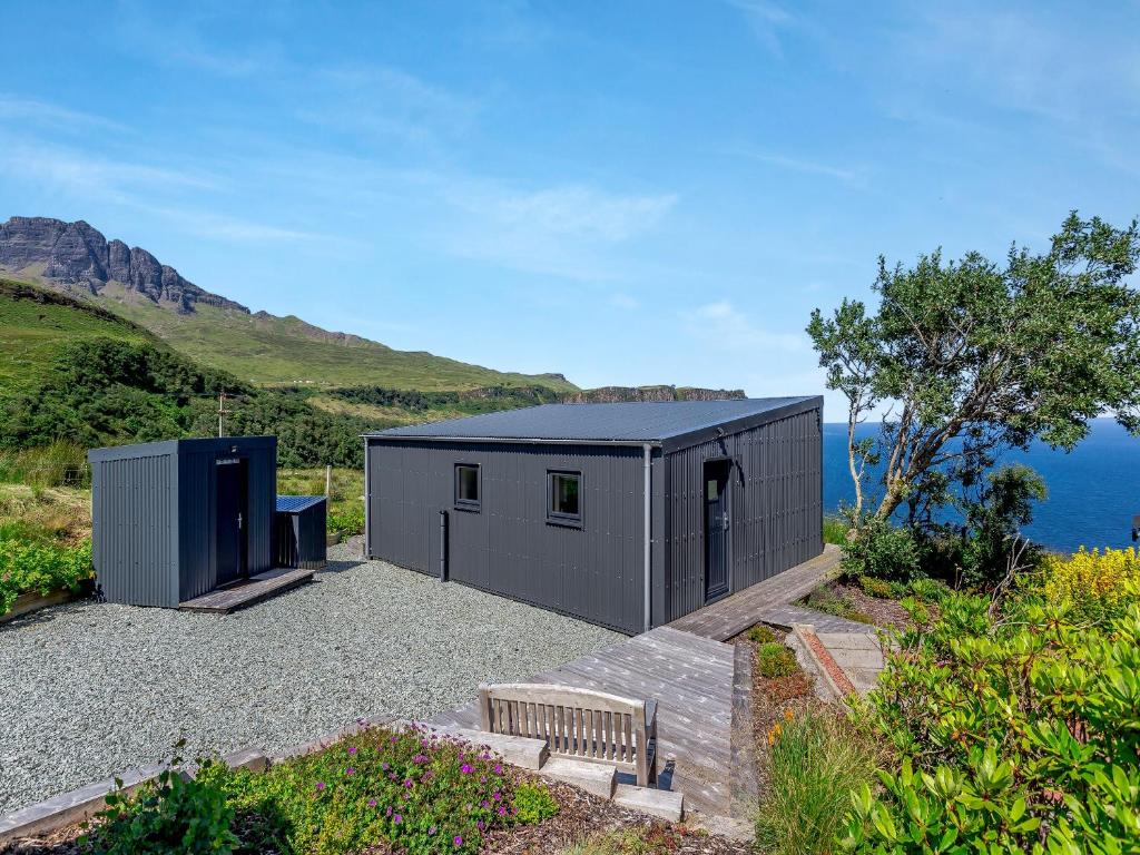 a small black building with a bench on a hill at The Bay in Culnacnoc